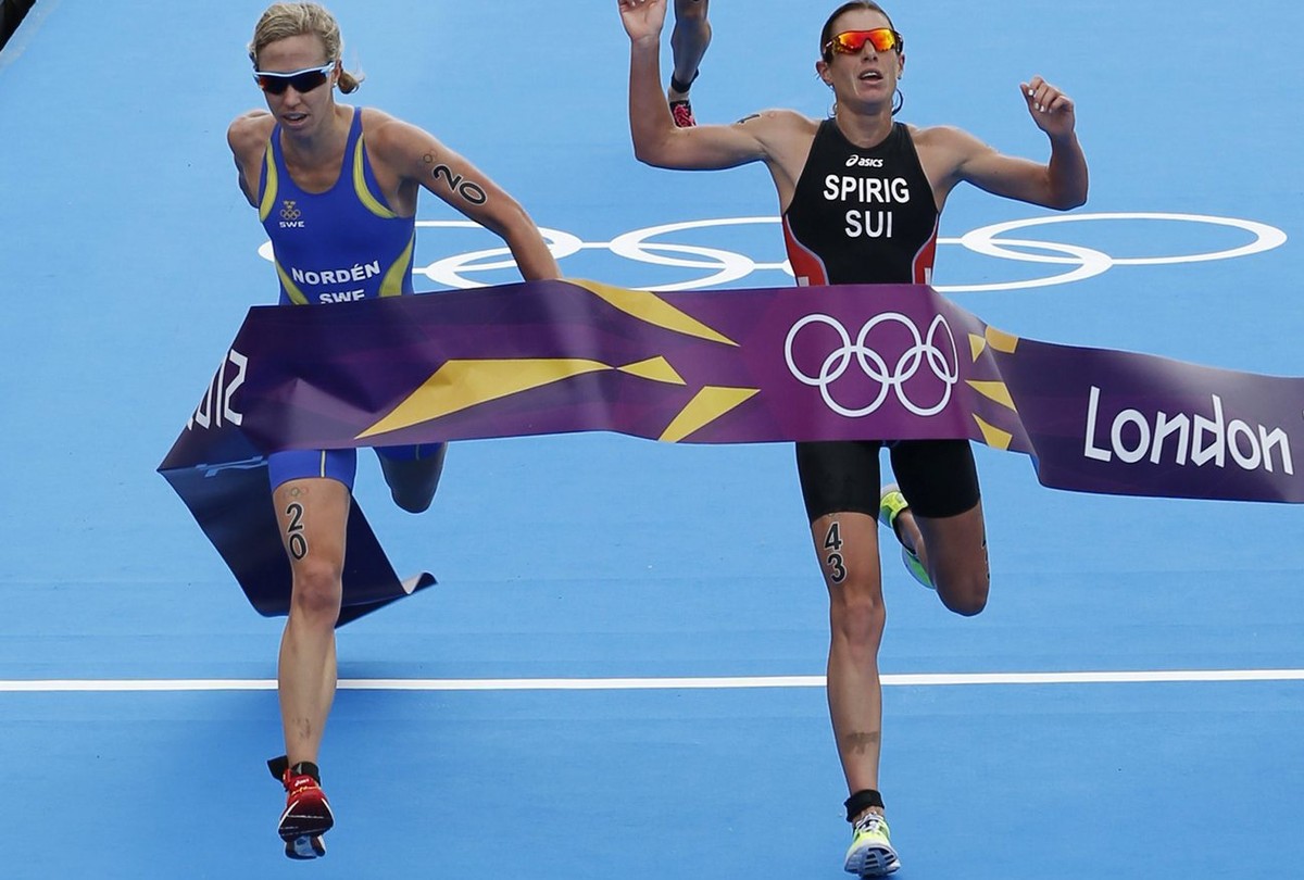 epa03339795 Nicola Spirig of Switzerland (R) crosses the finish line just ahead of Lisa Norden of Sweden in a sprint finish in the women's Triathlon held at Serpentine Lake in Hyde Park, in the L ...