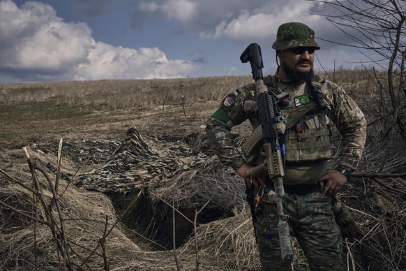 A Ukrainian soldier of the 28th brigade stands near a trench on the frontline near Bakhmut, Donetsk region, Ukraine, Monday, March 27, 2023. (AP Photo/Libkos)