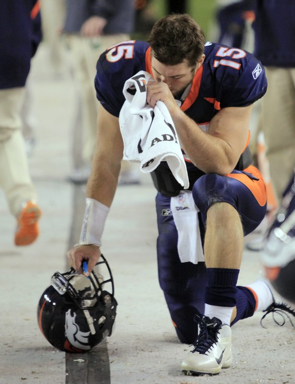 FILE - In this Nov. 17, 2011, file photo, Denver Broncos quarterback Tim Tebow (15) bows his head on the sidelines after scoring a touchdown against the New York Jets in the fourth quarter of an NFL f ...