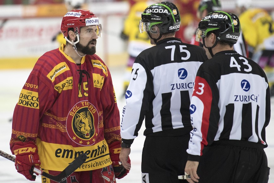 Tigers Roland Gerber, links, im Wortaustausch mit den Unparteiischen Roger Buergi, und Andreas Koch, rechts, waehrend dem Eishockey National League A Spiel zwischen den SCL Tigers und dem SC Bern, am  ...