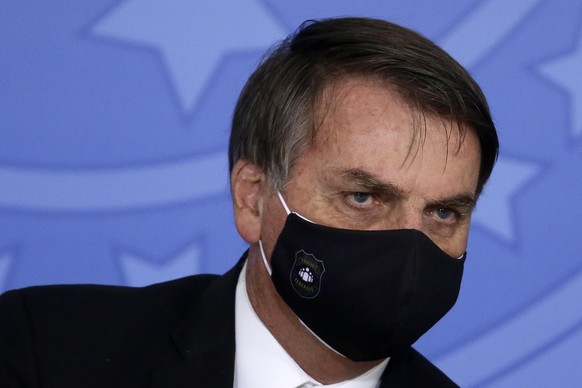Brazil's President Jair Bolsonaro wears a mask amid the COVID-19 pandemic, during an event promoting a government campaign against domestic violence at Planalto presidential palace in Brasilia, Brazil ...
