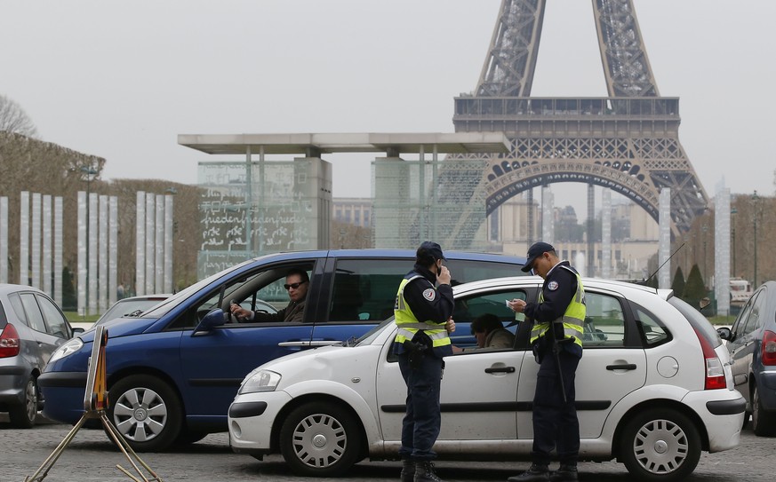 Die Pariser Polizei kontrolliert Autos. Abwechselnd dürfen Fahrzeuge mit gerader oder ungerader Nummer fahren.