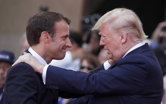 FILE - In this June 6, 2019 file photo, French President Emmanuel Macron, left, meets U.S President Donald Trump during a ceremony to mark the 75th anniversary of D-Day at the Normandy American Cemete ...