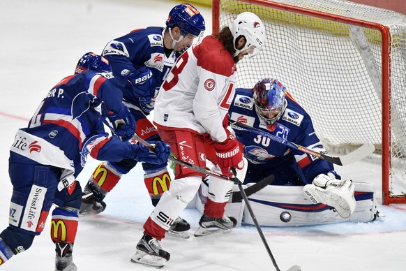 Der Lausanner Sven Ryser, links, bedraengt den Zuercher Torhueter Lukas Flueler, rechts, beim Eishockeyspiel der National League ZSC Lions gegen den HC Lausanne im Hallenstadion in Zuerich am Dienstag ...