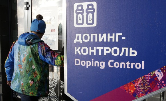 FILE - In this Feb. 21, 2014, file photo, a man walks past a sign reading doping control, at the Laura biathlon and cross-country ski center, at the 2014 Winter Olympics in Krasnaya Polyana, Russia. T ...