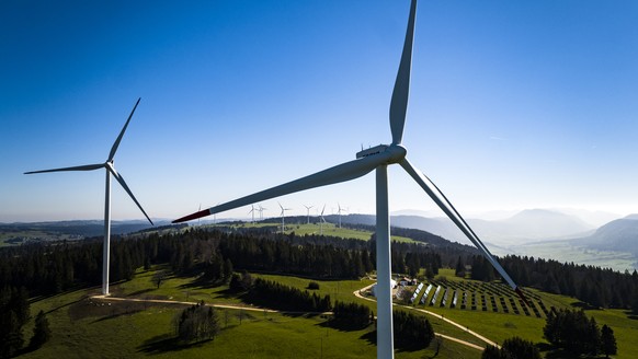 ARCHIVBILD - Nationalrat stimmt am 8. Maerz 2023 fuer Windenergieoffensive - Wind turbines from the JUVENT power plant and solar panels from the solar station of the Mont-Soleil are pictured on the Mo ...