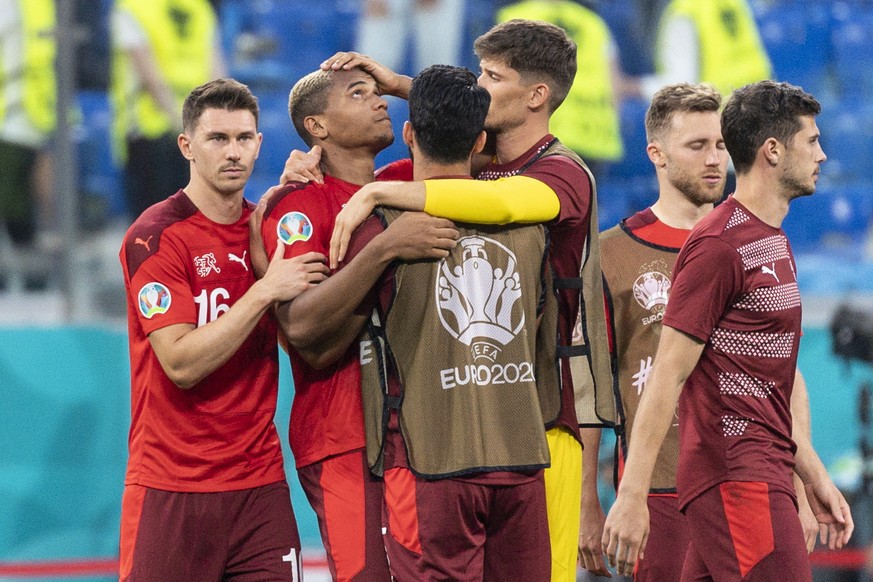 epa09318749 The Swiss players comfort defender Manuel Akanji (2-L) after he missed a penalty during the UEFA EURO 2020 quarter final match between Switzerland and Spain in St.Petersburg, Russia, 02 Ju ...