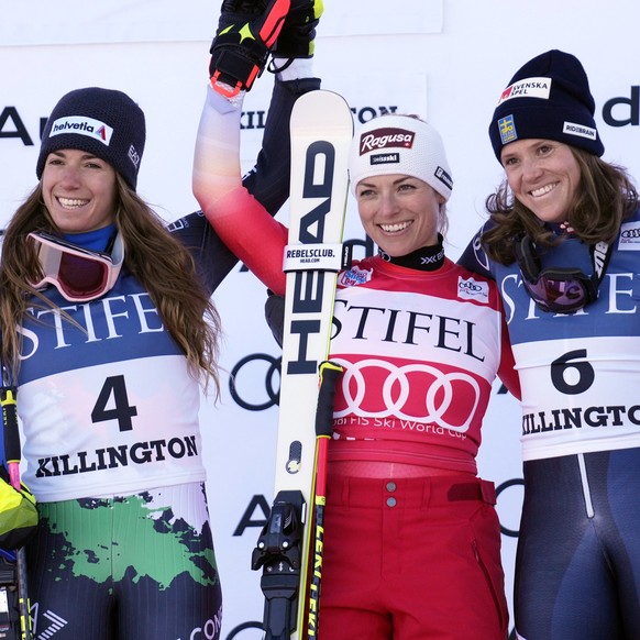 Switzerland&#039;s Lara Gut-Behrami, first place, center, and Italy&#039;s Marta Bassino, second place, left, and Sweden&#039;s Sara Hector, third place, acknowledge applause on the podium following a ...