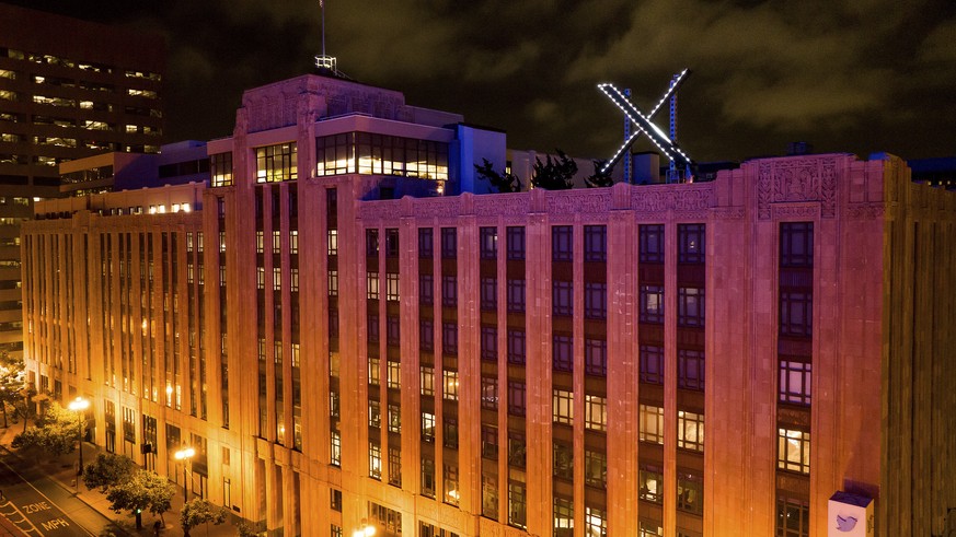 Workers install lighting on an &quot;X&quot; sign atop the company headquarters, formerly known as Twitter, in downtown San Francisco, Friday, July 28, 2023. (AP Photo/Noah Berger)