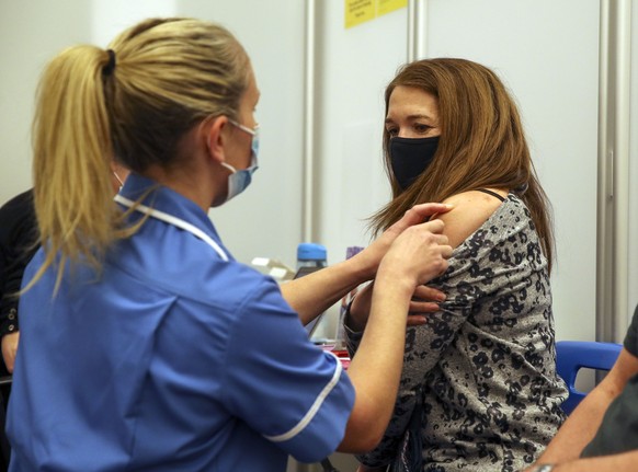 Caroline Nicolls receive an injection of the Moderna Covid-19 vaccine administered by nurse Amy Nash, at the Madejski Stadium in Reading, England, Tuesday April 13, 2021. Moderna is the third vaccine  ...