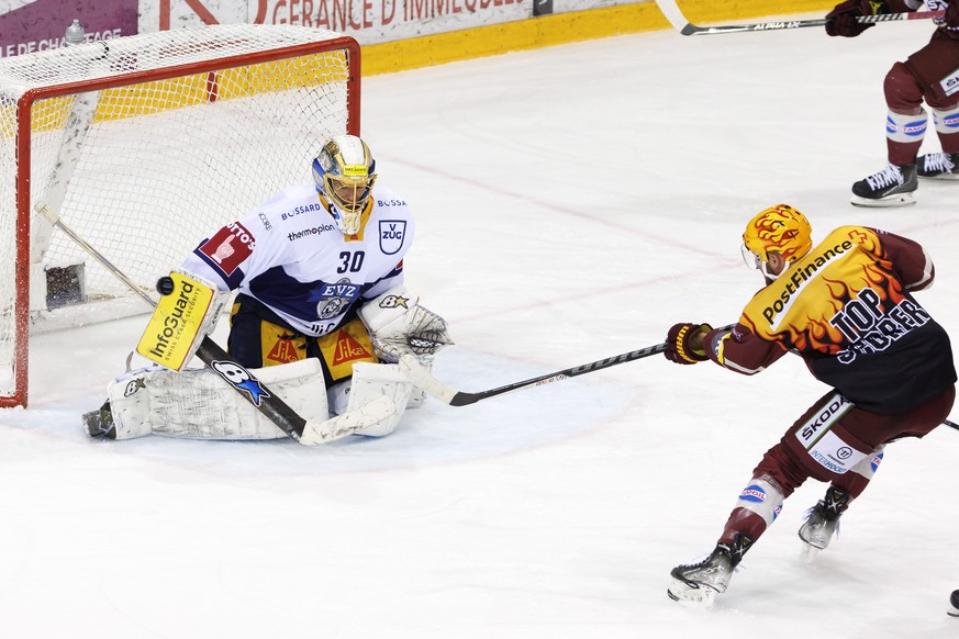 Zug&#039;s goaltender Leonardo Genoni, left, turns away the puck past PostFinance Top Scorer Geneve-Servette&#039;s forward Tanner Richard, right, during the third leg of the National League Swiss Cha ...