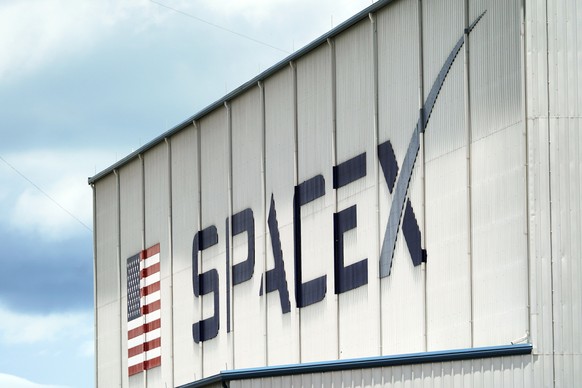FILE - a SpaceX logo is displayed on a building on May 26, 2020, at the Kennedy Space Center in Cape Canaveral, Fla. SpaceX, the rocket ship company run by Tesla CEO Elon Musk, has fired several emplo ...