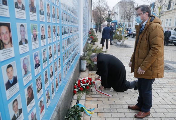 epa09743172 Ukrainian Foreign Minister Dmytro Kuleba (R) and OSCE Chairman-in-Office, Minister of Foreign Affairs of Poland Zbigniew Rau (C) attend a wreath-laying ceremony at the Memory wall of Ukrai ...