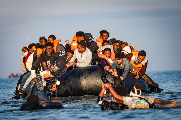 epa12409469 Migrants onboard an inflatable boat help others climb aboard during an attempt to cross the English Channel, off the beach of Gravelines, northern France, 27 September 2025. EPA/FADEL DAWO ...