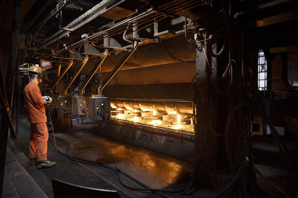 Ein Mitarbeiter verarbeitet fluessigen Stahl in der Produktionsstaette der Stahl Gerlafingen AG in Gerlafingen im Kanton Solothurn, Schweiz, fotografiert am Montag, 18. September 2023. Die Schweizer S ...