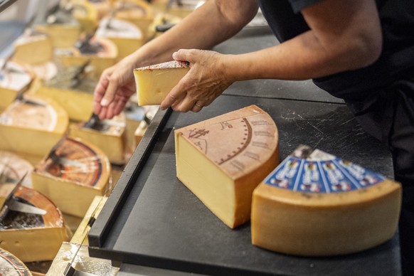 epa12289800 A person arranges Swiss cheese at the cheese factory in Sumiswald, Emmental region, Switzerland, 08 August 2025. Since 07 August, additional tariffs of 39 percent have been imposed by the  ...