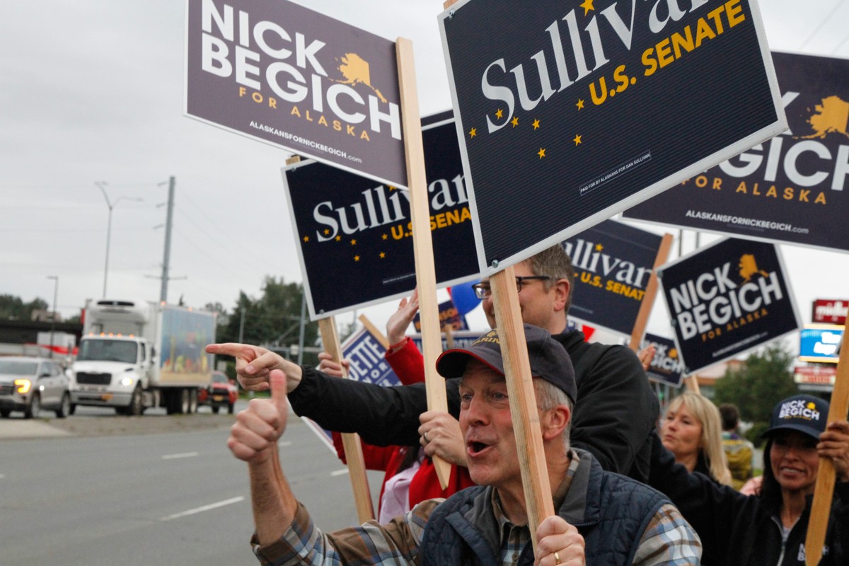 KEYPIX -Sen. Dan Sullivan, R-Alaska, who is seeking a third term, flashes a thumbs up after a passing motorist honked during a sign waving event at an intersection on primary election day in Anchorage ...