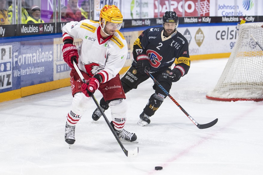 Le top scorer lausannois Dustin Jeffrey, gauche, lutte pour le puck avec le defenseur fribourgeois Marc Abplanalp, droite, lors de la rencontre du championnat suisse de hockey sur glace de National Le ...