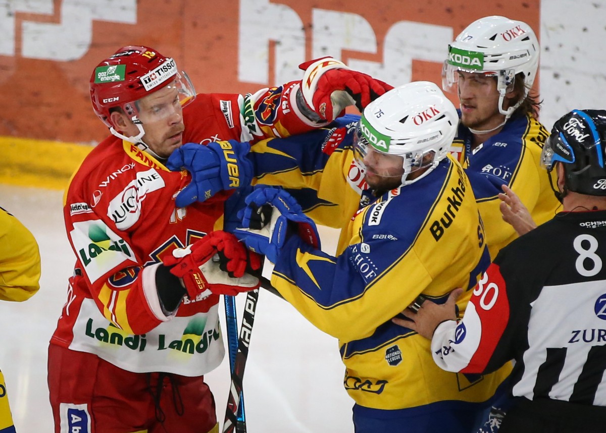 Biels Anssi Salmela, links, gegen Davos' Lukas Stoop, Mitte, und Thierry Bader, rechts, im Eishockey Meisterschaftsspiel der National League zwischen dem EHC Biel und dem HC Davos am Dienstag, 24 ...