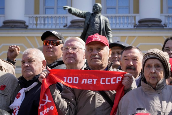 Communists party supporters gather near a statue of Soviet Union founder Vladimir Lenin to mark Labor Day, also known as May Day in St. Petersburg, Russia, Monday, May 1, 2023. (AP Photo/Dmitri Lovets ...