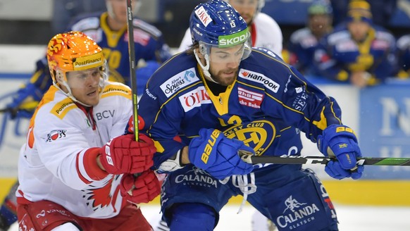 Der Lausanner PostFinance TopScorer Christoph Bertschy, links, gegen den Davoser Luca Hischier, beim Eishockey-Qualifikationsspiel der National League A zwischen dem HC Davos und dem Lausanne HC, am S ...