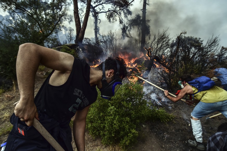 Volunteers work to extinguish a fire in Yatagan of the Mugla province, Turkey, Friday Aug. 6, 2021. Thousands of people fled wildfires burning out of control in Greece and Turkey on Friday, as a protr ...