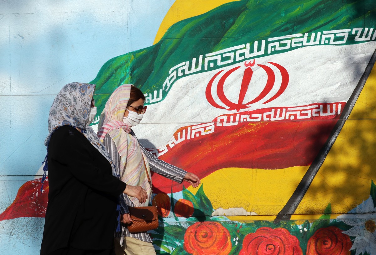 epa08570960 Iranian women wearing face masks walk past a mural of Iran's national flag in Tehran, Iran, 28 July 2020. According to figures released by the Iranian Health Ministry, Iran hits a new ...