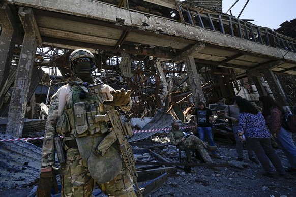 FILE - A Russian soldier speaks to foreign journalists in front of the ruined Metallurgical Combine Azovstal, in Mariupol, on the territory which is under the Government of the Donetsk People&#039;s R ...