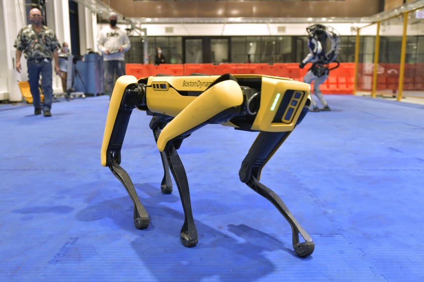 Marc Raibert, left rear, founder and chair of Boston Dynamics watches one of the company&#039;s Spot robots during a demonstration, Wednesday, Jan. 13, 2021, at their facilities in Waltham, Mass.(AP P ...