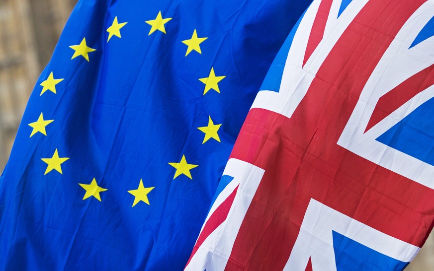 epa06185123 An Union (R) flag and an EU flag flown by anti-Brexit protesters outside the Houses of Parliament in London, Britain, 05 September 2017. Brexit secretary Davis is expected to update on the ...