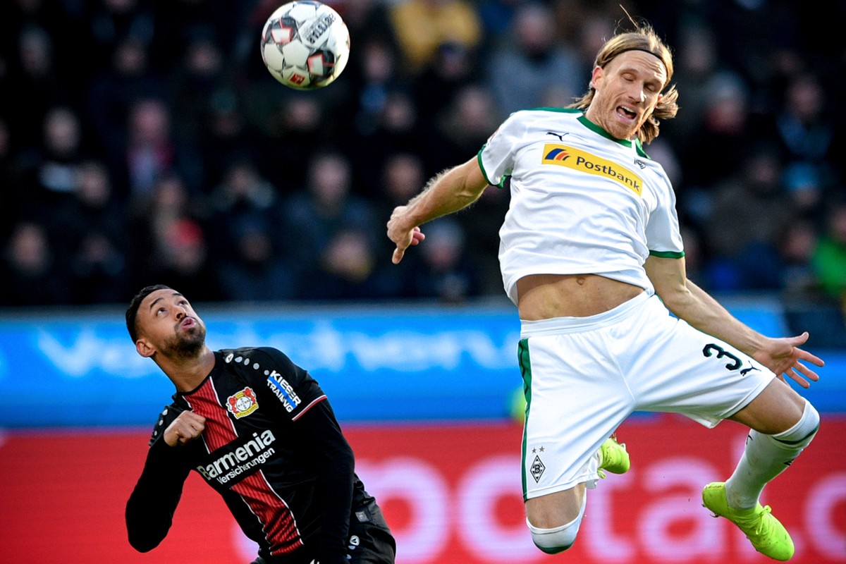 epa07300168 Leverkusen's Karim Bellarabi (L) in action against Moenchengladbach's Michael Lang (R) during the German Bundesliga soccer match between Bayer Leverkusen and Borussia Moenchengla ...