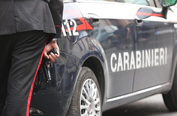 epa04749989 An Italian Carabinieri officer holds his gun ready as police reacts to a shooting spree that left at least four people dead and five others wounded in the area of Secondigliano, Naples, It ...