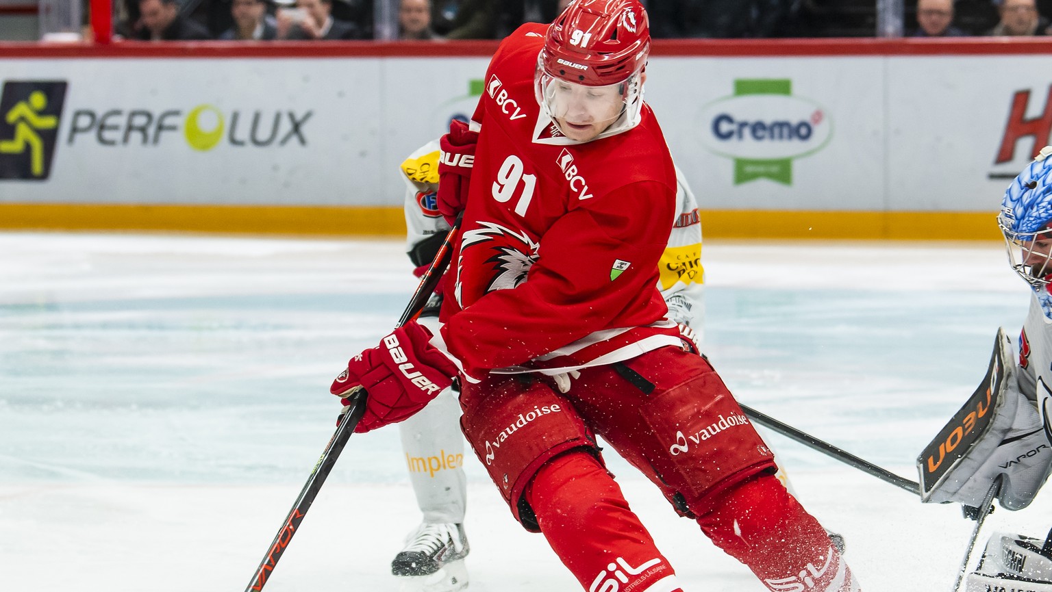 L&#039;attaquant lausannois Joel Vermin, gauche, lutte pour le puck avec le gardien Fribourgeois Reto Berra, droite, lors de la rencontre du championnat suisse de hockey sur glace de National League e ...