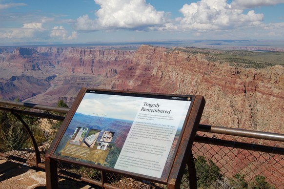 This Sept. 12, 2013 photo released by the Grand Canyon National Park Service, shows a National Historical Landmark plate overlooking the east end of the Grand Canyon, Ariz. Two commercial airplanes, U ...