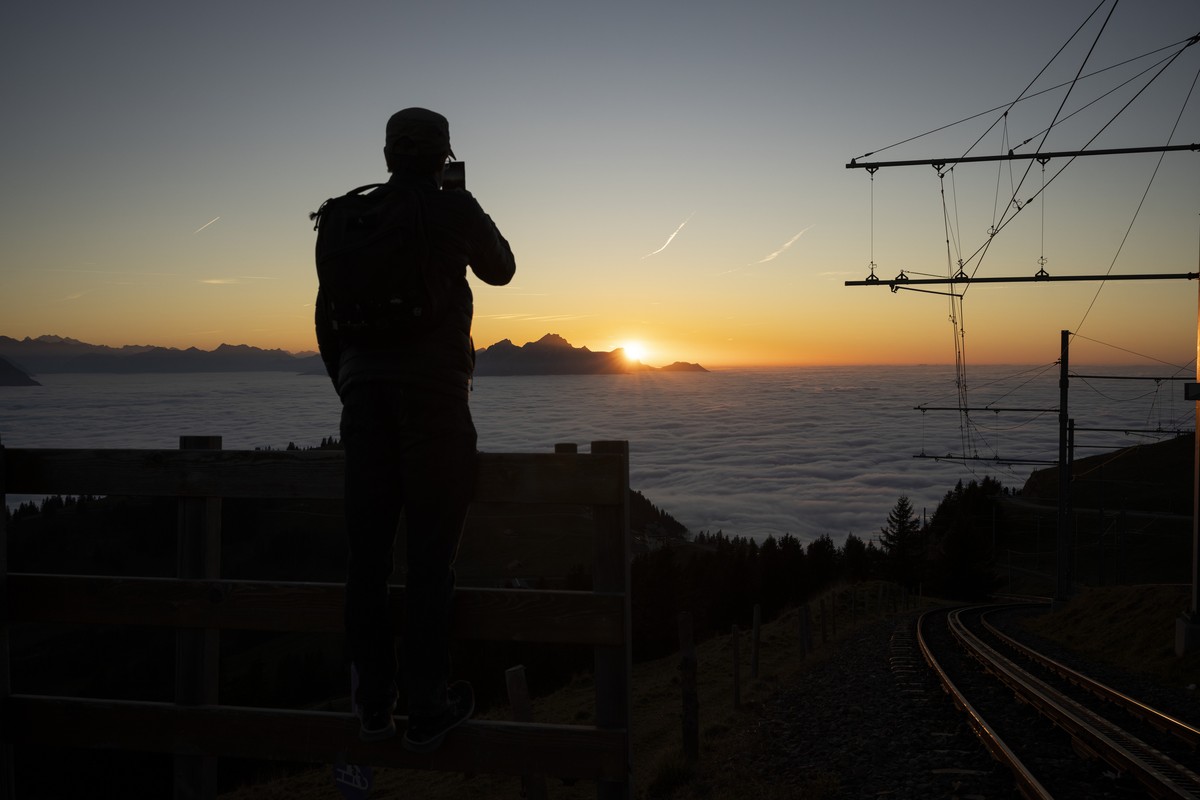 Besucher auf der Rigi geniessen den Sonnenuntergang ueber dem Nebelmeer hinter dem Pilatus, fotografiert bei der Bahnstation Rigi-Kulm am Samstag 2. November 2024. (KEYSTONE/Gaetan Bally)