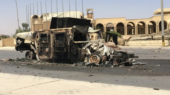 A burnt vehicle belonging to the Iraqi security forces is left on a road one day after radical Sunni Muslim insurgents seized control of the city of Mosul June 11, 2014. Sunni insurgents from an al Qaeda splinter group extended their control from the northern city of Mosul on Wednesday to an area further south that includes Iraq's biggest oil refinery in a devastating show of strength against the Shi'ite-led government.  REUTERS/Stringer (IRAQ - Tags: CIVIL UNREST POLITICS CRIME LAW)