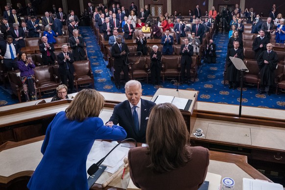 epaselect epa09795451 US President Joe Biden shakes hands with Speaker of the House Nancy Pelosi and Vice President Kamala Harris at the conclusion of his State of the Union address before a joint ses ...