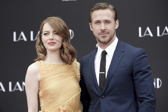 Emma Stone, left, and Ryan Gosling pose for photos after placing their hands and feet in wet cement during a ceremony at TCL Chinese Theatre on Wednesday, Dec. 7, 2016, in Los Angeles, Calif. (Photo b ...