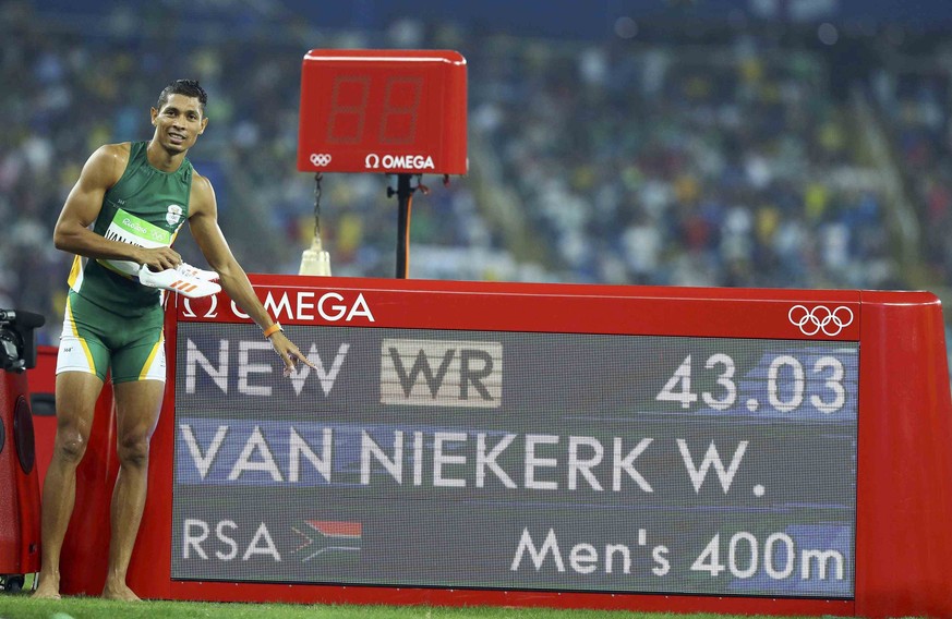 2016 Rio Olympics - Athletics - Final - Men&#039;s 400m Final - Olympic Stadium - Rio de Janeiro, Brazil - 14/08/2016. Gold medalist Wayde van Niekerk (RSA) of South Africa points to the board showing ...