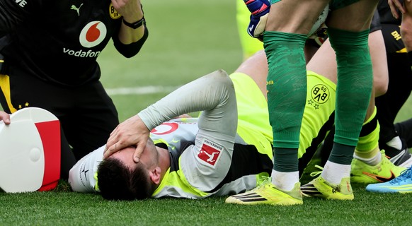 epa12898247 Niklas Suele of Dortmund is injured during the German Bundesliga soccer match between TSG 1899 Hoffenheim and Borussia Dortmund in Sinsheim, Germany, 18 April 2026. EPA/RONALD WITTEK CONDI ...