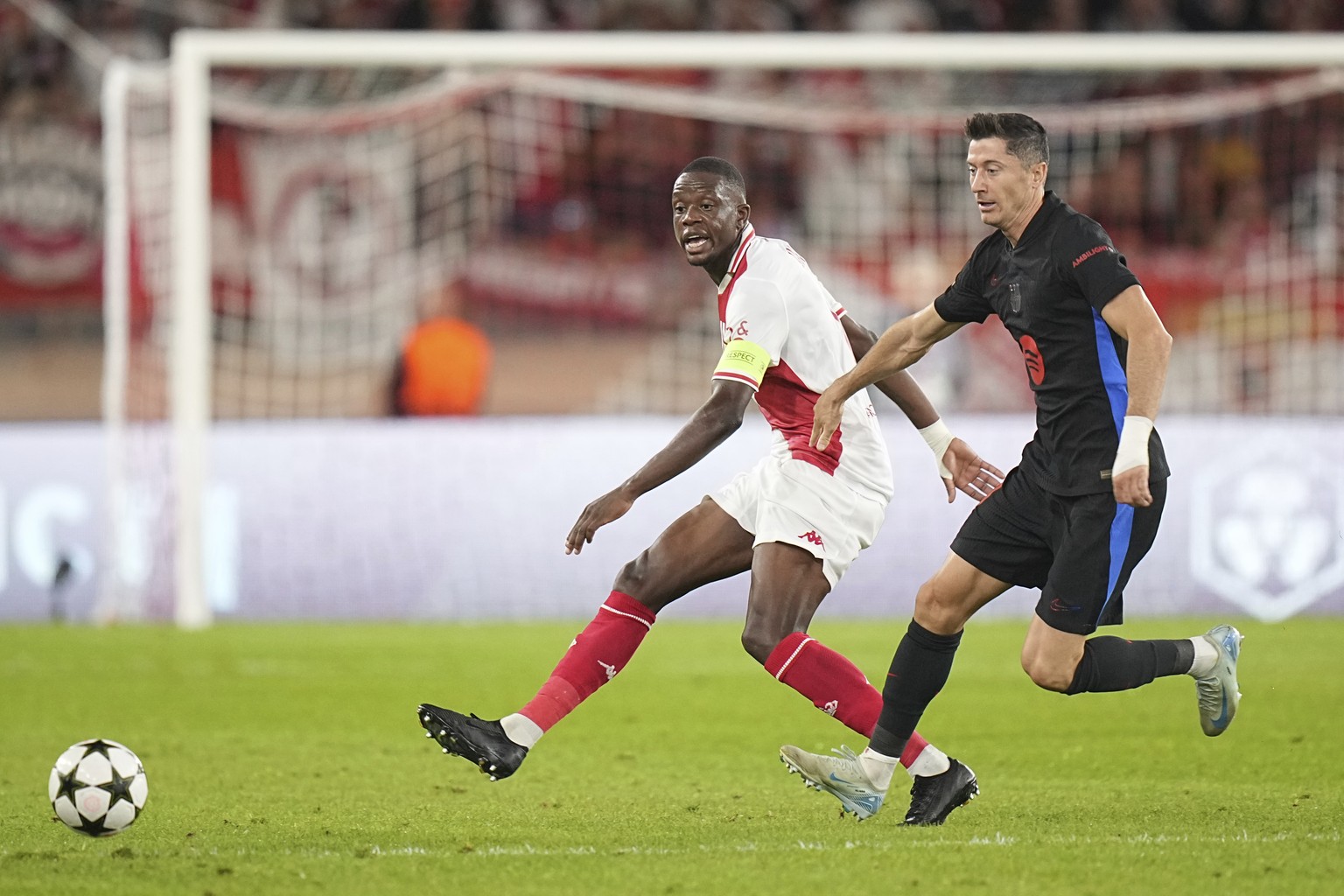 Monaco&#039;s Denis Zakaria, left, passes the ball next to Barcelona&#039;s Robert Lewandowski during the Champions League opening phase soccer match between Monaco and Barcelona at the Louis II stadi ...
