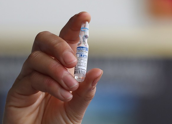 epa09071312 A Tunisian nurse shows a vial of the Russian Sputnik V vaccine against COVID-19 at a hospital in Tunis, Tunisia, at the launch of a vaccination program, 13 March 2021. Tunisia has received 30,000 doses of Russia's COVID-19 vaccine, Sputnik V. Health workers are a priority for vaccination.  EPA/MOHAMED MESSARA