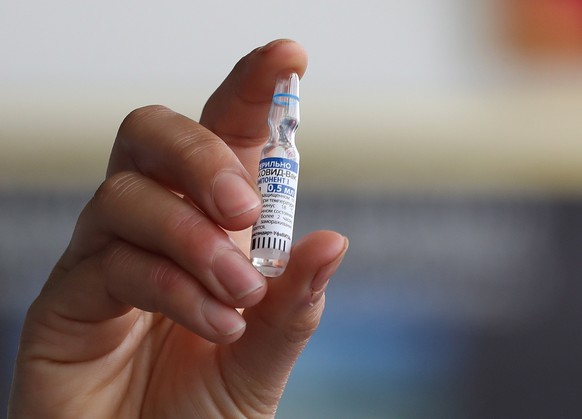 epa09071312 A Tunisian nurse shows a vial of the Russian Sputnik V vaccine against COVID-19 at a hospital in Tunis, Tunisia, at the launch of a vaccination program, 13 March 2021. Tunisia has received ...