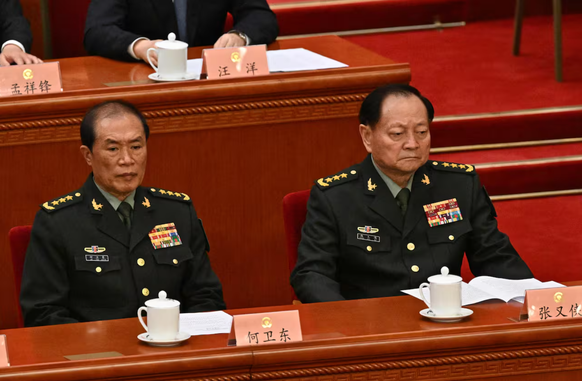 He Weidong (links) wird Korruption vorgeworfen.