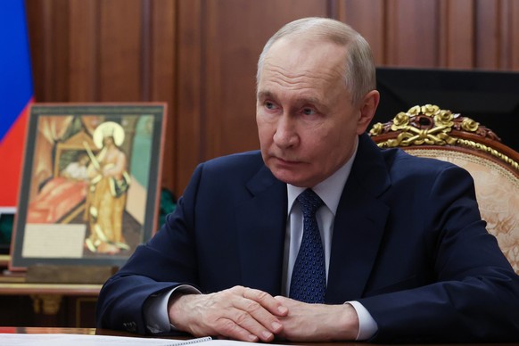 Russian President Vladimir Putin attends a meeting with Chairman of the Board of the Circle of Kindness Foundation, Orthodox Archpriest Alexander Tkachenko, at the Kremlin in Moscow, Russia, Friday, F ...