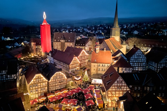 KEYPIX - A 42-meter-high candle, which is an illuminated medieval tower covered with a red blanket, shines in the historic city centre of Schlitz, Germany, Saturday, Dec. 13, 2025. (AP Photo/Michael P ...