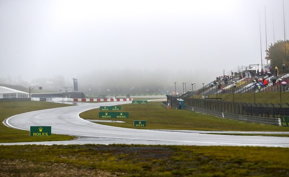 epa08731255 Spectators wait in stands in the rain as the start of the first practice session is delayed during the Formula One Eifel Grand Prix at the Nuerburgring race track in Nuerburg, Germany, 09  ...