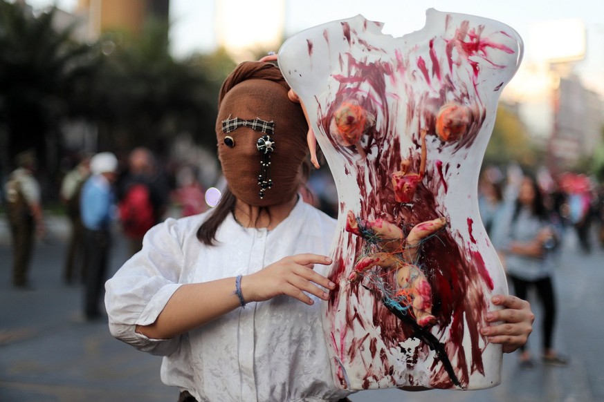 epa06590608 A masked woman holds a mannequin during the International Women&#039;s Day protest to demand equal rights in Santiago, Chile, 08 March 2018. The demonstration is an expression of denunciat ...