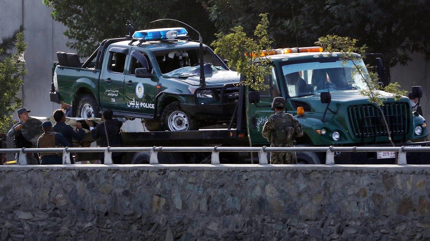 epa05525736 A wreck of a police car is lifted as Afghan security officials inspect the site of a twin bomb blast near the defense Ministry, in Kabul, Afghanistan, 05 September 2016. According to media ...