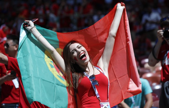 A woman holds a Portuguese flag prior to the group B match between Portugal and Morocco at the 2018 soccer World Cup in the Luzhniki Stadium in Moscow, Russia, Wednesday, June 20, 2018. (AP Photo/Hass ...